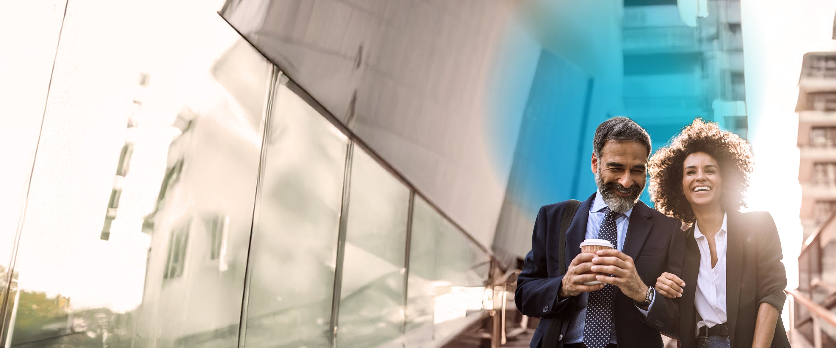 A multiethnic businessman holding a coffee cup and businesswoman walking and smiling while locking arms with one another and a blue gradient hovering behind them  