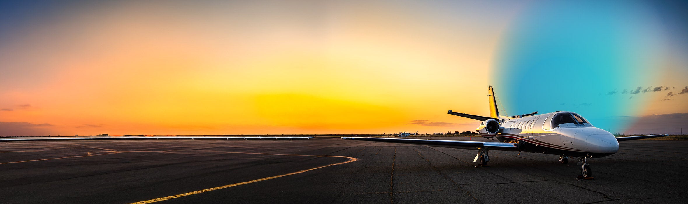 Airplane in a landing strip with the sunset in the background and a blue gradient hovering to the right of it 