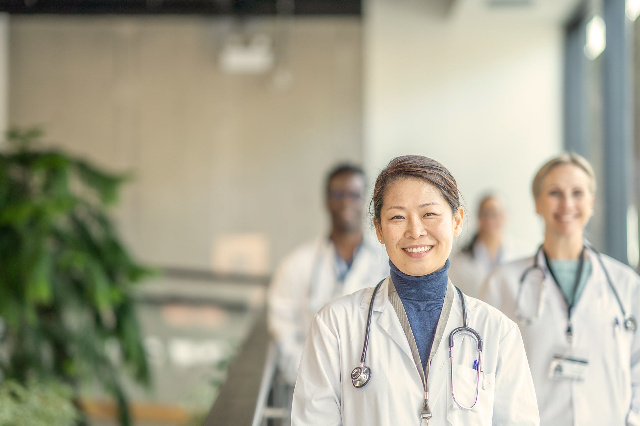 A multiethnic group of medical professionals smiling in the hospital and looking into the camera 