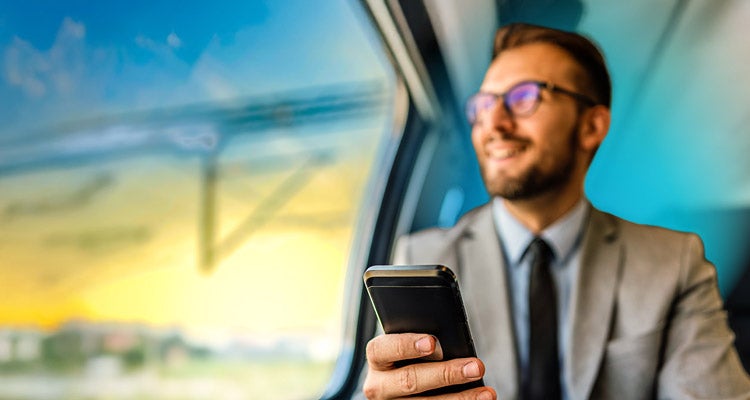 Caucasian businessman wearing glasses traveling in a car looking out of the window with a phone in his hand and a blue gradient hovering around him 