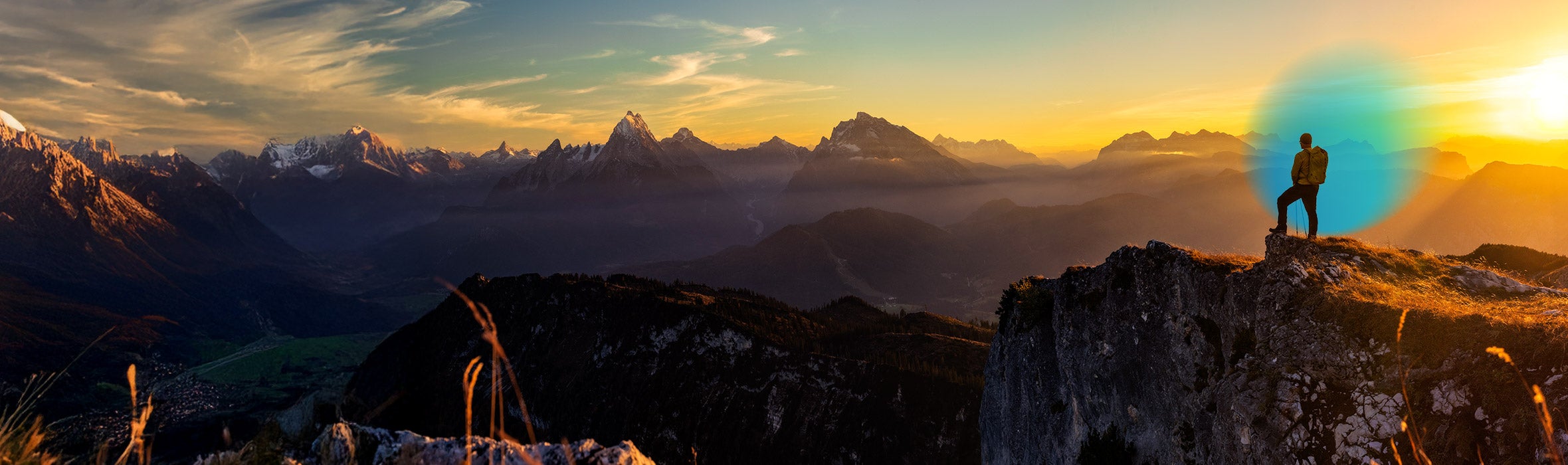 Man wearing a backpack on the top of a mountain surrounded by other mountains during the sunset and a blue gradient hovering around him 