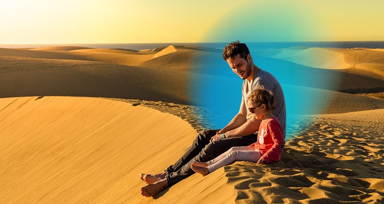 Father and young daughter sitting in a sanded area and a blue gradient hovering around them 