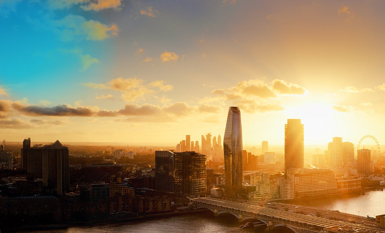 Modern city skyline with buildings and bridges lit up by the golden afternoon sky 