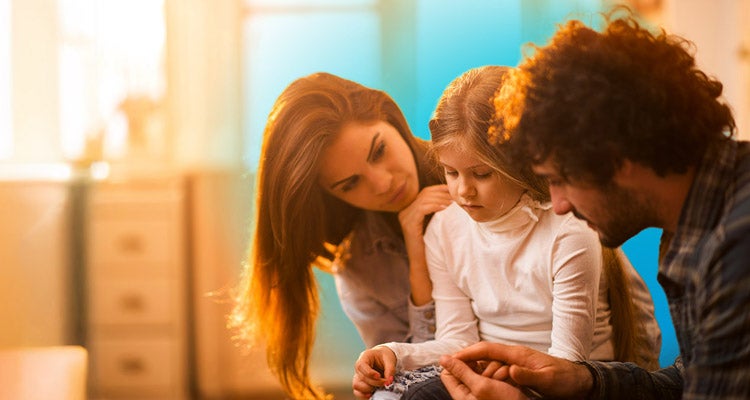 Sad little girl sitting between two parents being consoled by them and blue circled gradient hovering behind them