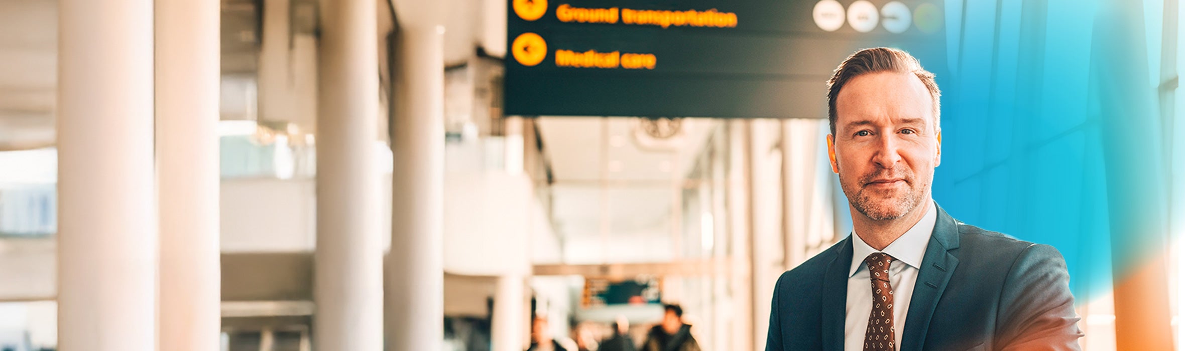 Caucasian businessman in an airport terminal slightly smiling with a blue gradient hovering around him 