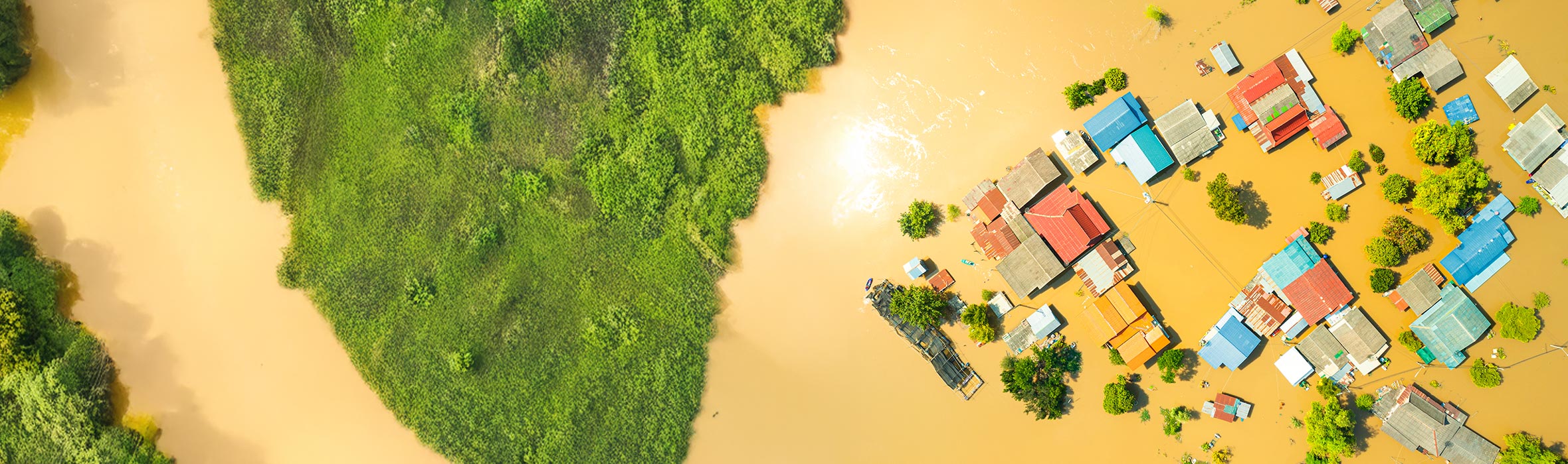 A high up view overlooking homes and surrounding land and water 