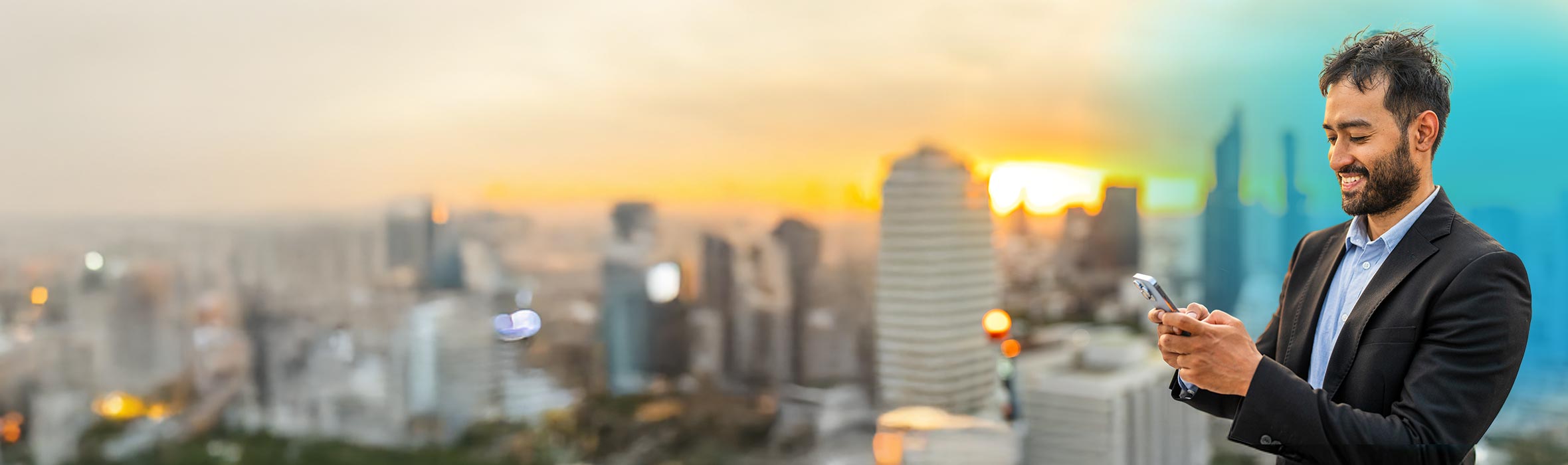 A businessman smiling while texting on his phone standing somewhere that is overlooking a modern city skyline with blue gradient hovering over man