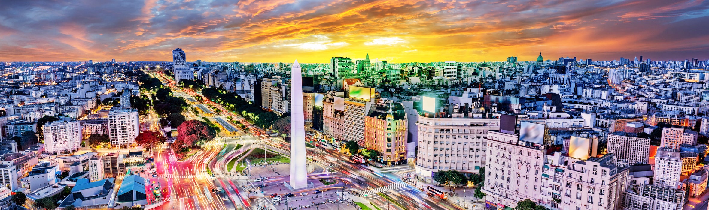 View of Buenos Aires, Argentina, featuring the Obelisco centered among traffic and surrounding city buildings at sunset
