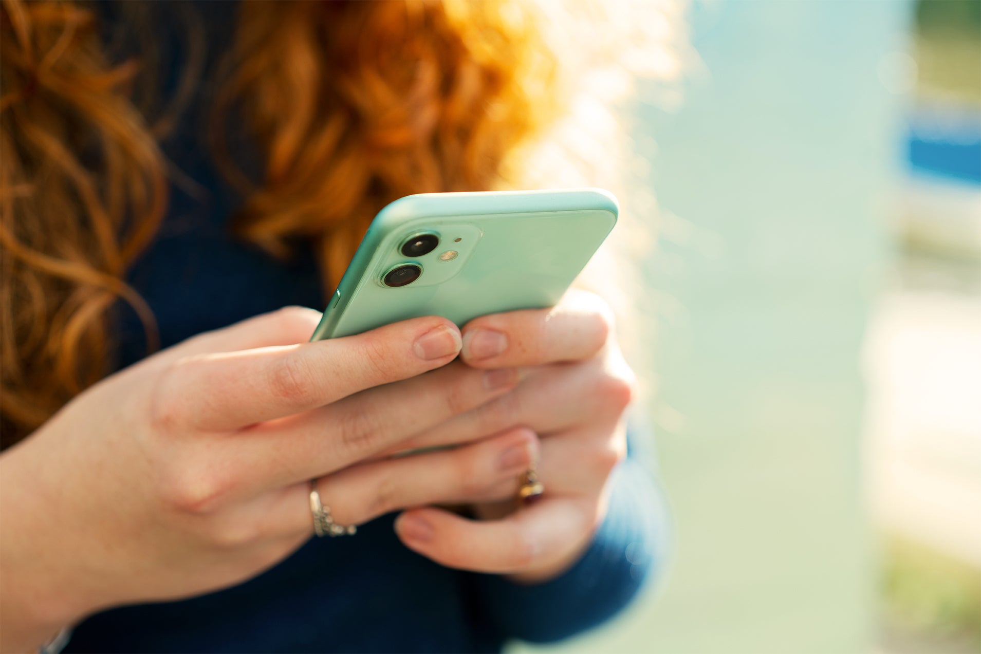 Closeup of a woman's hands using her smartphone with a blurred background 
