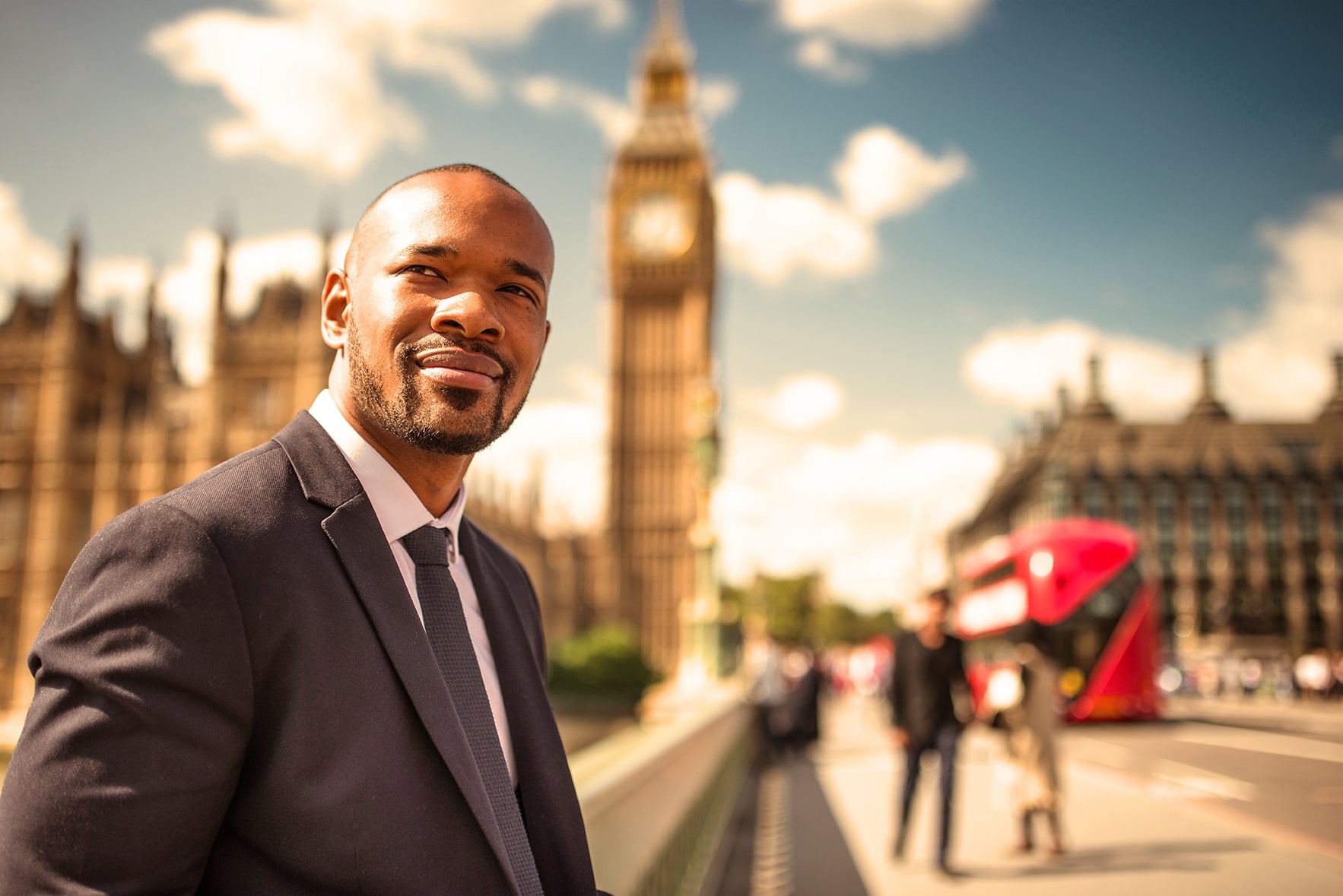 Businessman in a suit looking off into a distance with downtown London in the background